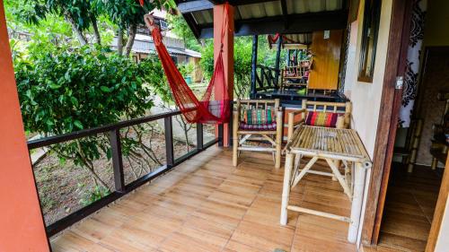 a balcony with chairs and a hammock on a house at Sairee View Resort in Koh Tao