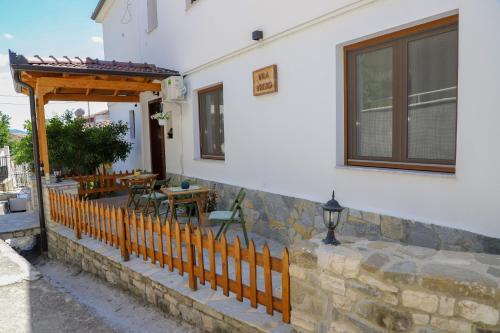 a house with a wooden fence and a patio at Vila Vreko in Berat