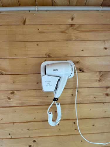 a white hair dryer hanging on a wall at Le dôme en seine, proche Giverny in Moisson