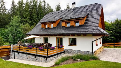 une petite maison blanche avec un toit noir dans l'établissement Chalupa U Juráša, à Horní Bečva