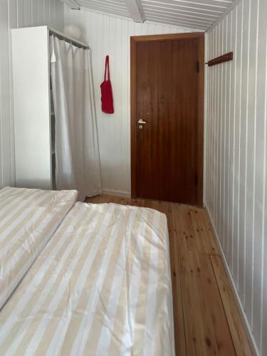a bedroom with a bed and a wooden door at Wonderfull House By Liseleje Strand in Melby