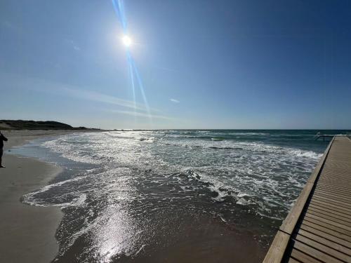 a beach with the sun shining on the water at Wonderfull House By Liseleje Strand in Melby