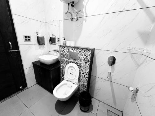 a bathroom with a toilet and a sink at Rishikesh-Tapovan - Lakshman Jhula - Triveni Ghat in Narendranagar