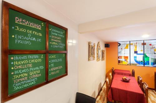 a restaurant with a table and a chalkboard on the wall at Hotel Francés La Maison in Pasto