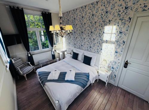 EtbosにあるLe Manoir des Etangsのベッドルーム1室(青と白の壁紙のベッド1台付)