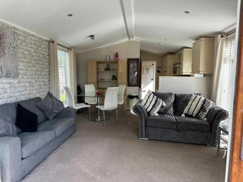 a living room with two couches and a kitchen at Wentworth Lodge in Tydd Saint Giles