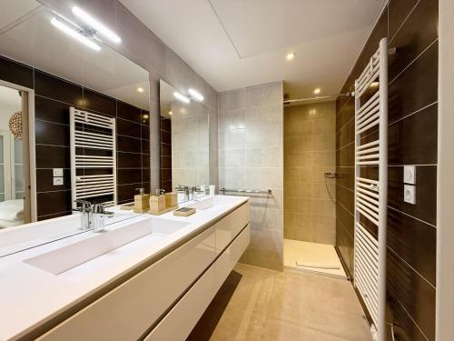 une salle de bain avec deux lavabos et une douche dans l'établissement Appartement Massimo, à Sainte-Maxime