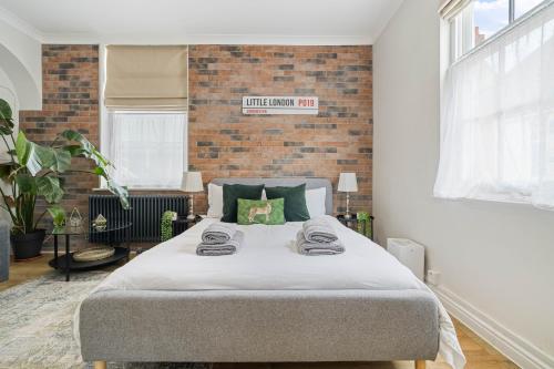 a bedroom with a bed with a brick wall at City Centre Entire Studio Apartment- Self check in in Chichester