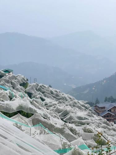 a large pile of snow on top of a mountain at Saanjh by Limitless Stays in Bāgi