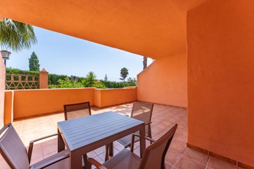 a patio with a table and chairs on a balcony at Royal Marbella Golf Resort in Estepona