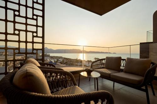 a living room with chairs and a view of the ocean at Rocca a Mare Heraklion - Handwritten Collection in Heraklio Town