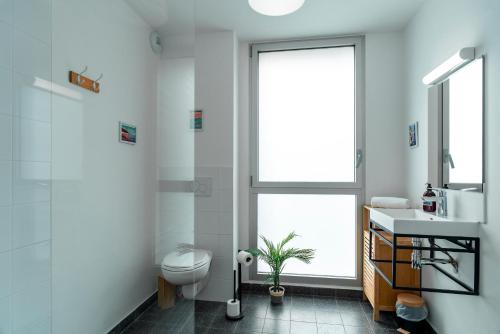 a bathroom with a toilet and a sink and a window at Le Zeste Marin - Proche baie de Quiberon in Plouharnel