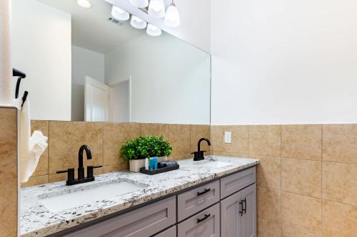 a bathroom with two sinks and a large mirror at Family-Ready 4BR with Yard & Kids Playground in Cedar Creek