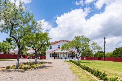 a white house with a red fence and trees at Family-Ready 4BR with Yard & Kids Playground in Cedar Creek