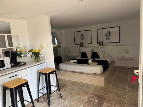 a bedroom with a bed and two stools in it at Suite Prestige in Codolet