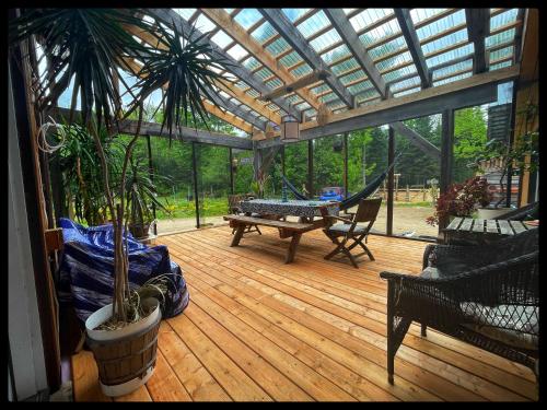 a screened in porch with a hammock and a table at gite comme un accord in Saint Mathieu Du Parc