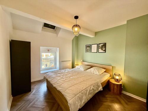 a bedroom with a large bed with green walls at L'Appart des Copains, beau duplex & centre-ville in Gérardmer
