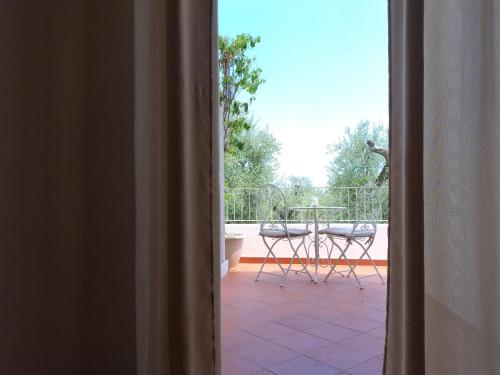 Blick auf eine Terrasse mit einem Tisch und Stühlen in der Unterkunft Libeccio in Mattinata