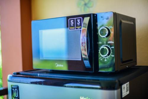 a microwave sitting on top of a refrigerator at Sairee View Resort in Koh Tao