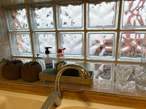 a sink in a kitchen with a window with dishes at Aithra House Αίθρα in Toroni
