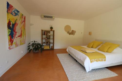 a bedroom with a large bed with yellow pillows at Louis Henry in Saint-Pierre-des-Champs