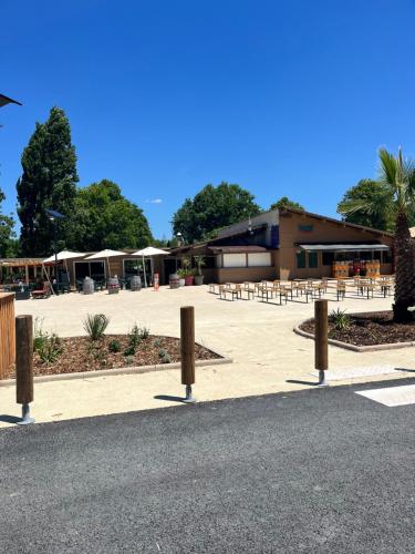 a group of tables and chairs in a parking lot at Camping 4 étoiles Mobile home 4 à 6 personnes in Aureilhan