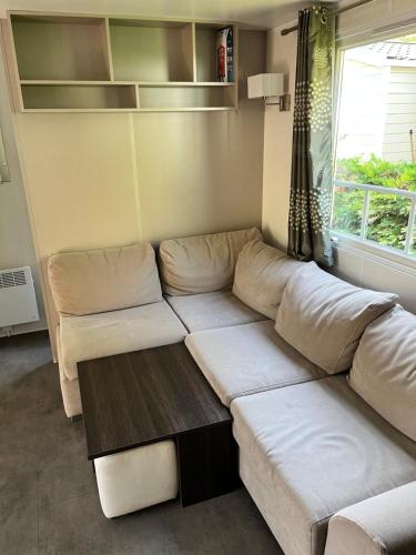 a living room with a couch and a table at Camping 4 étoiles Mobile home 4 à 6 personnes in Aureilhan