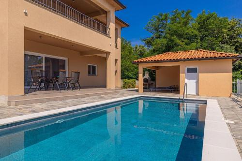a swimming pool in front of a house at Villa NOOK in Risika