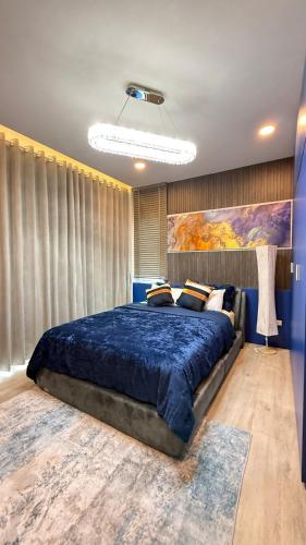 a bedroom with a large bed with a blue comforter at De Flourishing Hill Pool Villa , Cha Am in Cha Am