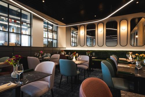 a restaurant with tables and chairs and windows at Focus Hotel Premium Wrocław in Wrocław