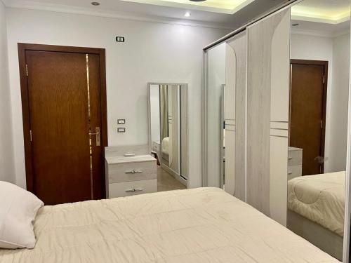 a bedroom with two beds and a large mirror at Luxurious apartment in New cairo
