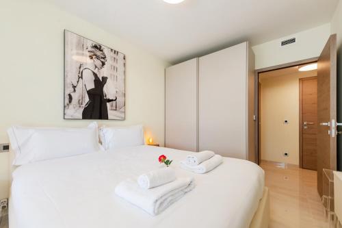 une chambre avec un lit blanc avec des serviettes dessus dans l'établissement Monaco - Terrasse vue mer - Piscine - Parking - DR, à Saint-Roman