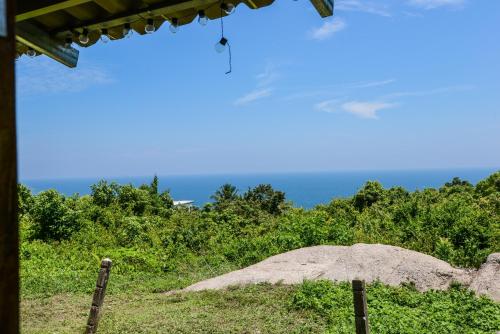 an umbrella on a hill with the ocean in the background at Sairee View Resort in Koh Tao