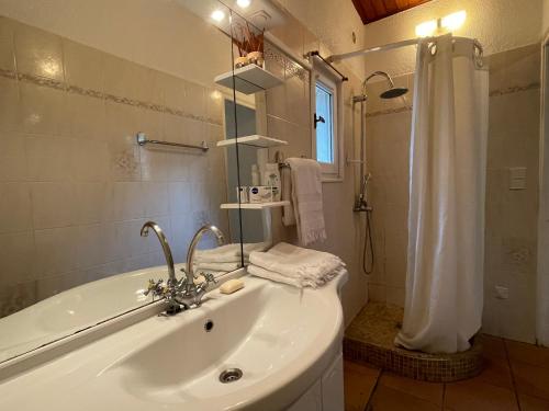 une salle de bain blanche avec lavabo et douche dans l'établissement Deux mini villas distancees 10 metres pour 6 personnes, à Saint-Florent