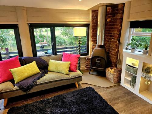 a living room with a couch and a wood stove at River View in Tonbridge