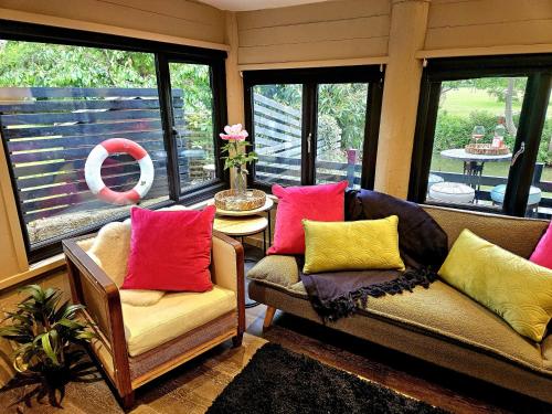 a living room with two chairs with colorful pillows at River View in Tonbridge