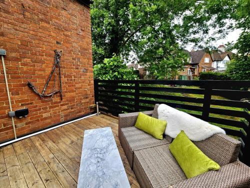a patio with a couch and a brick wall at River View in Tonbridge