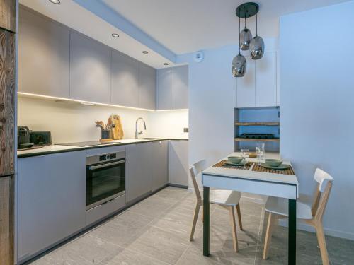 une cuisine avec une table et des chaises dans une pièce dans l'établissement Cocon intime avec WiFi, garage, et accès direct aux pistes dans résidence neuve à Val d'Isère - FR-1-694-339, à Val dʼIsère