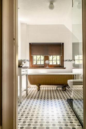 a bathroom with a bath tub and a window at Caer Beris Hotel in Builth Wells