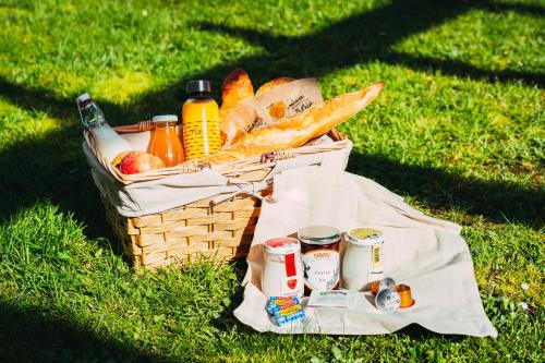 Una cesta de picnic con pan y bebidas en el césped. en Résidence Odalys - Les Coteaux de Sarlat, en Sarlat-la-Canéda