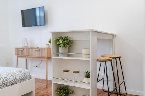 une étagère blanche avec des plantes et une table dans l'établissement Le Moana, 2pers 5min Disneyland Paris, à Montévrain