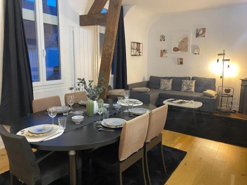 une salle à manger avec une table et un canapé dans l'établissement Passo, à Rouen