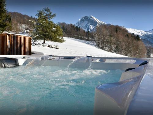 une personne dans un bain à remous dans la neige dans l'établissement Chalet La Parenthèse - OVO Network, à Samoëns