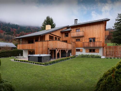 a large wooden house with a large yard at Chalet La Parenthèse - OVO Network in Samoëns