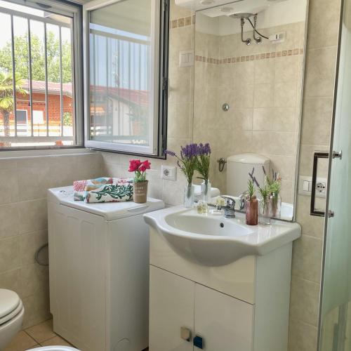 a white bathroom with a sink and a toilet at Bnbook Emozione Lago in Dormelletto