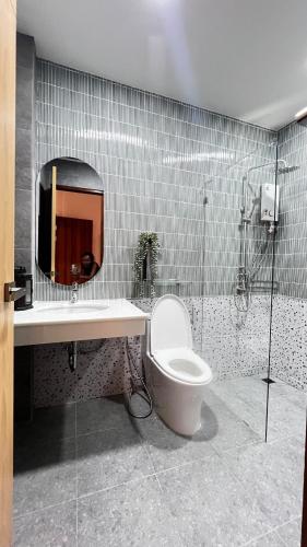 a bathroom with a toilet and a sink and a mirror at De Flourishing Hill Escape #2 in Ban Hup Kaphong