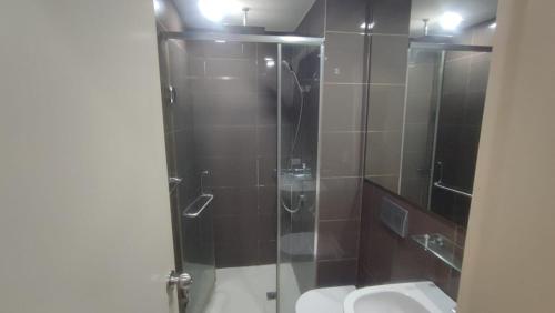 Un baño con ducha, inodoro y lavabo. en Aveline Suites Riverline, en Manila