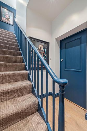 a staircase with a blue door in a house at City Centre Apartment with Cathedral Views and FREE Parking- Self check in in Chichester