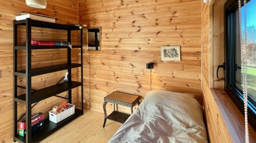 a bedroom with a bed and a wooden wall at Architect-Designed Holiday Home By Isefjord in Kirke-Hyllinge