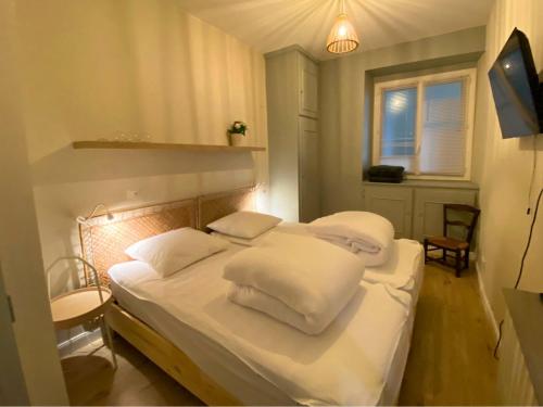 une chambre avec deux lits avec draps blancs et oreillers dans l'établissement Le Sidonie, à Luchon